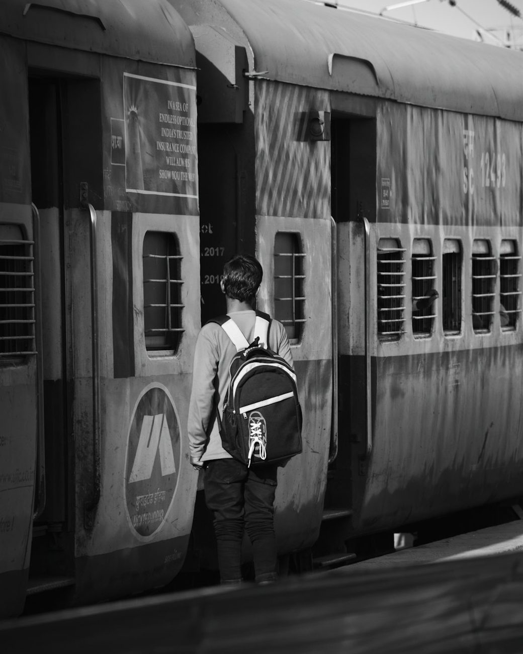 A traveller with a backpack beside a train